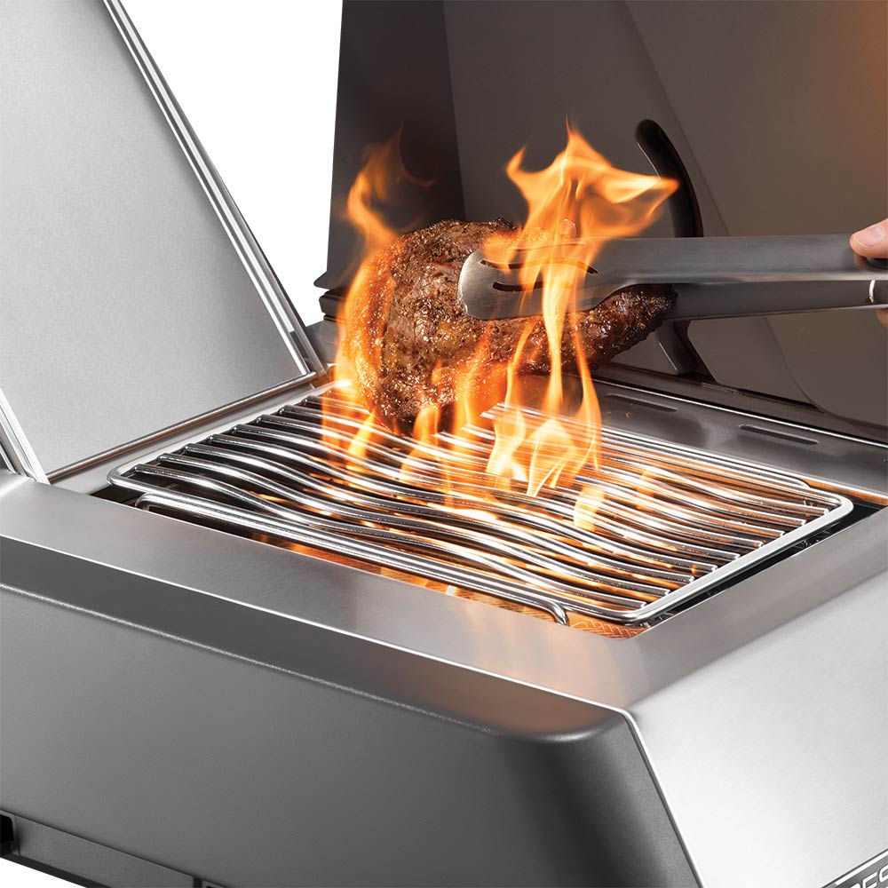 Gas grill side burner with glowing flames under a metal grate and control area