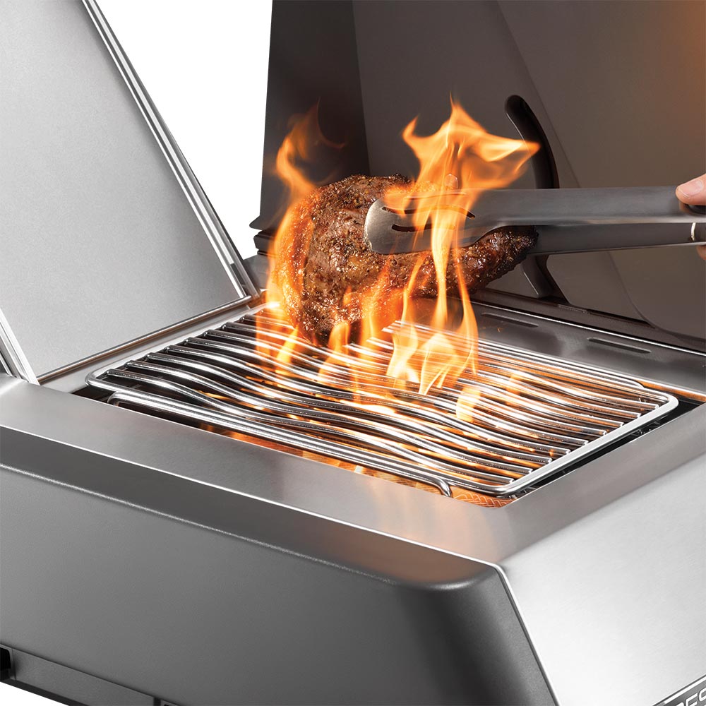 Gas grill side burner with open lid and intense flames under the cooking grate