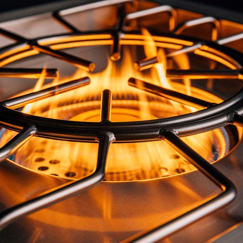 Burner flame over stainless burner grates and cooking ring on gas cooktop