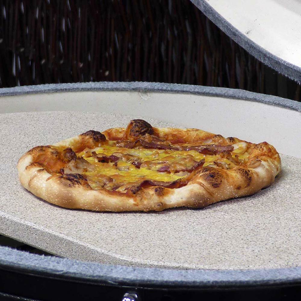 Oval baking stone with speckled surface, holding a pizza with browned crust