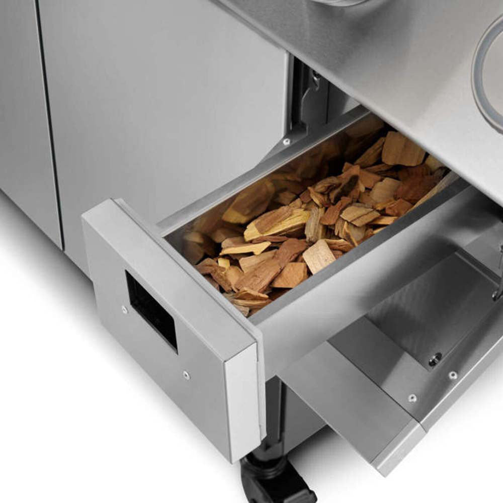 Stainless steel smoker box drawer filled with wood pieces for grilling flavor