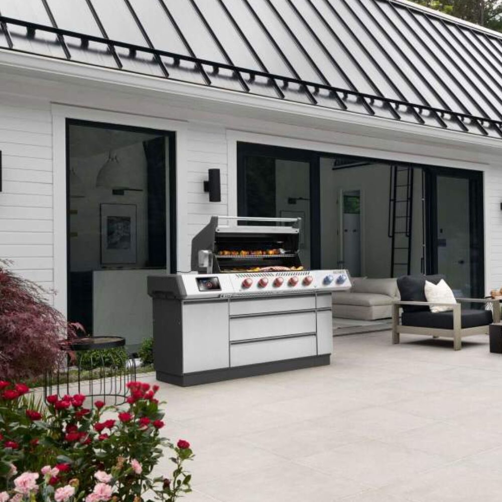 Stainless steel gas grill with multiple burner controls and side cabinet doors