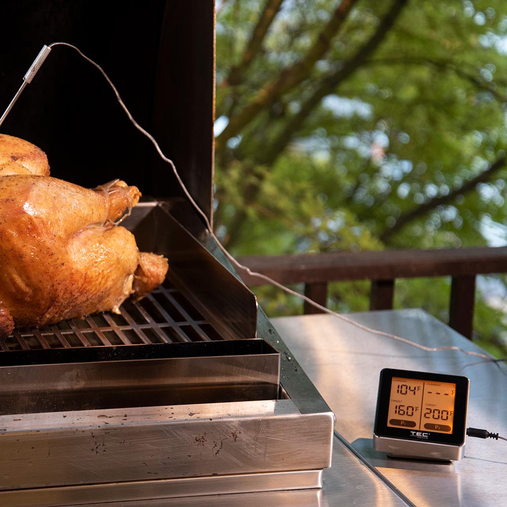 Wireless meat thermometer with dual probe leads and digital display showing temperatures