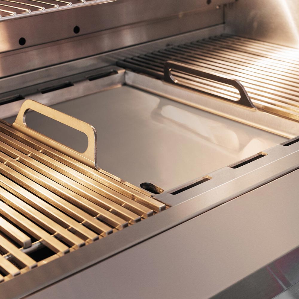 Gas grill cooking area with cast-iron grates over a stainless steel drip tray and burner area