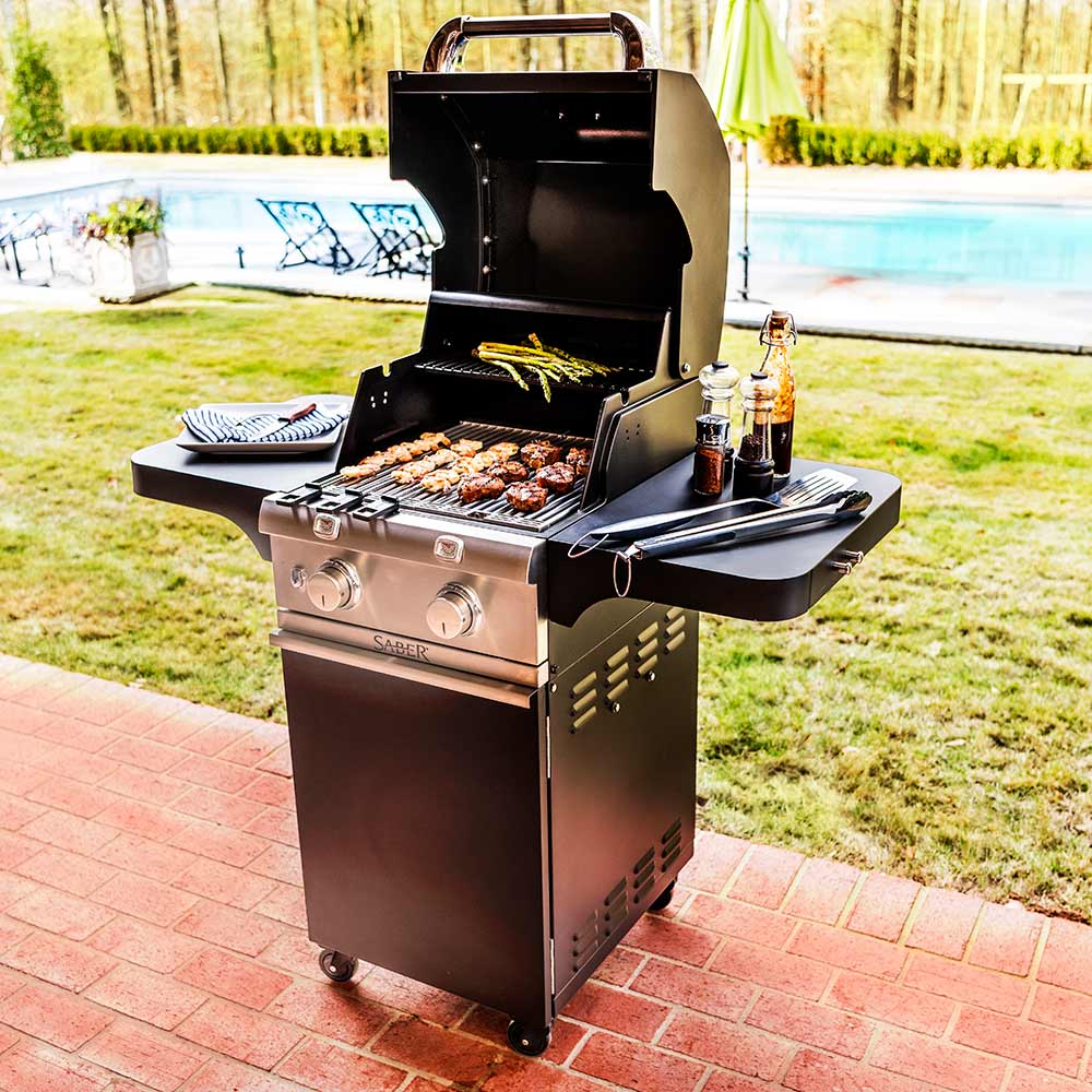 Black 2-burner infrared grill with lid open and food cooking on the grates