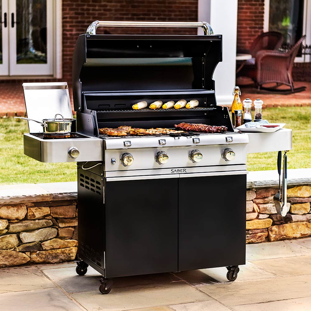 Infrared grill outdoors with lid open and grilling food on stainless grates