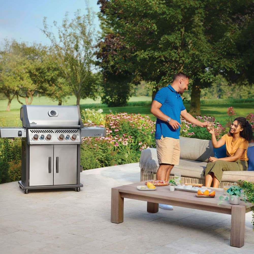 Stainless steel gas grill on cart in an outdoor patio setting