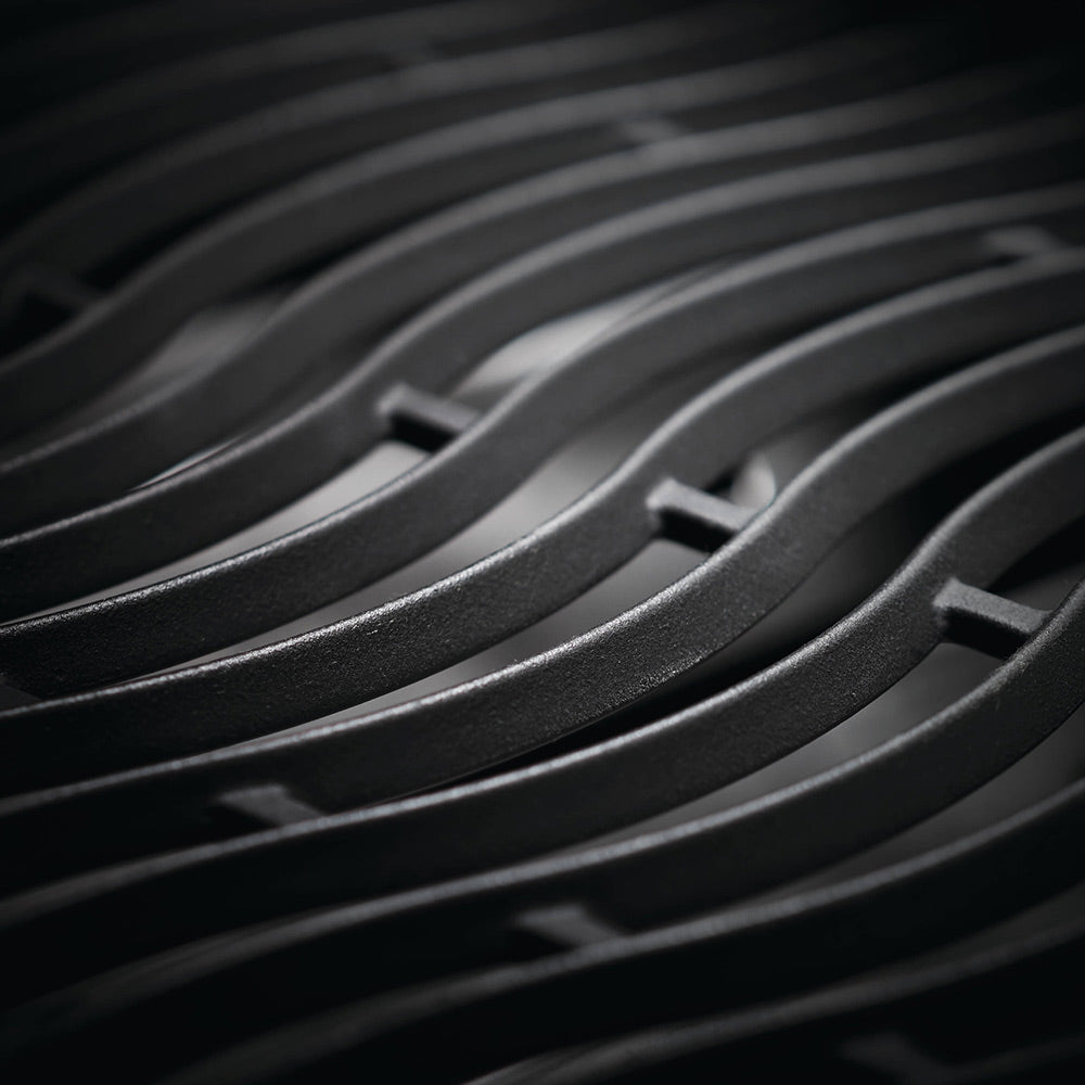 Close-up of black grill grates with curved, ridged cooking bars