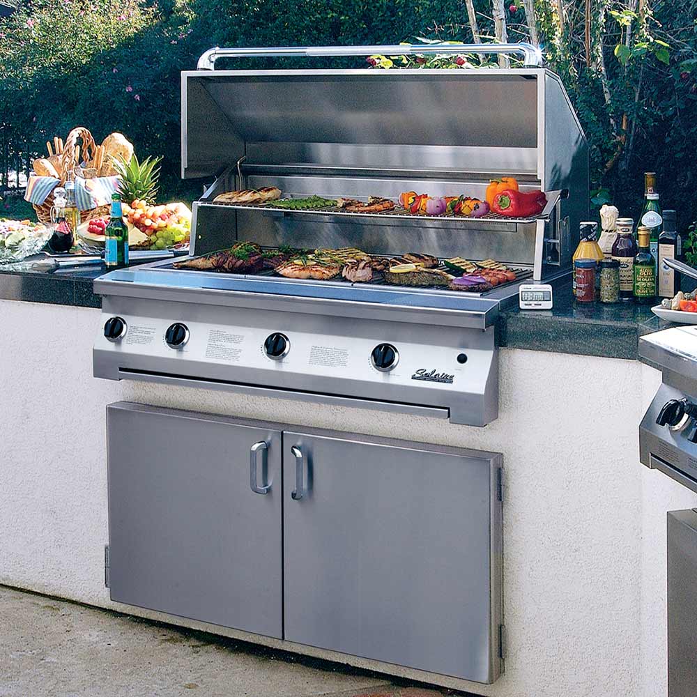 Stainless built-in grill with open hood and cooked food on the grates