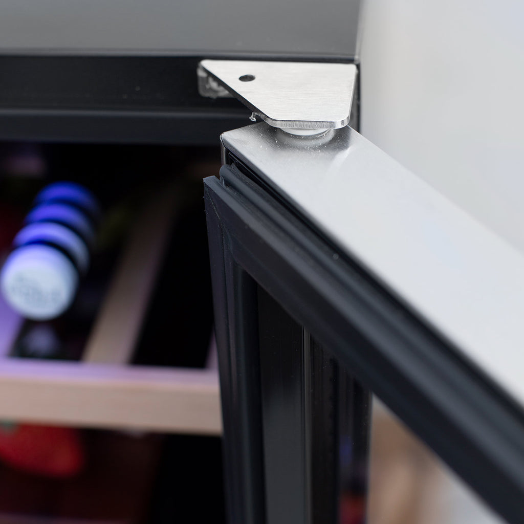 Wine cooler door hinge and metal latch edge, close-up view