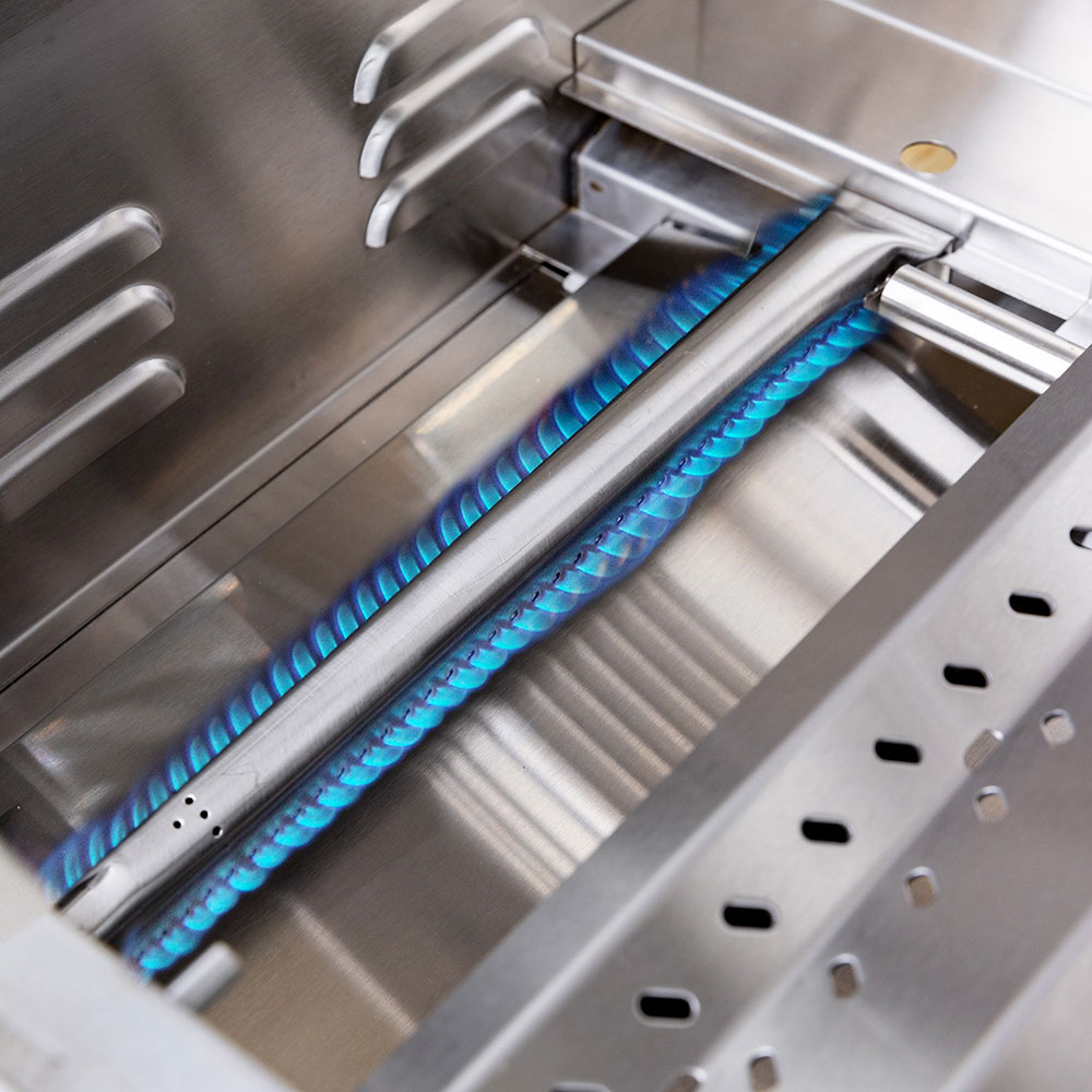 Freestanding gas grill burner with blue flames under the cooking grates.