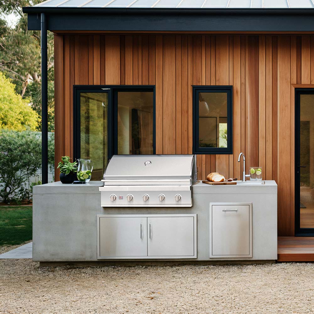 Built-in stainless steel gas grill with control panel and side storage cabinet