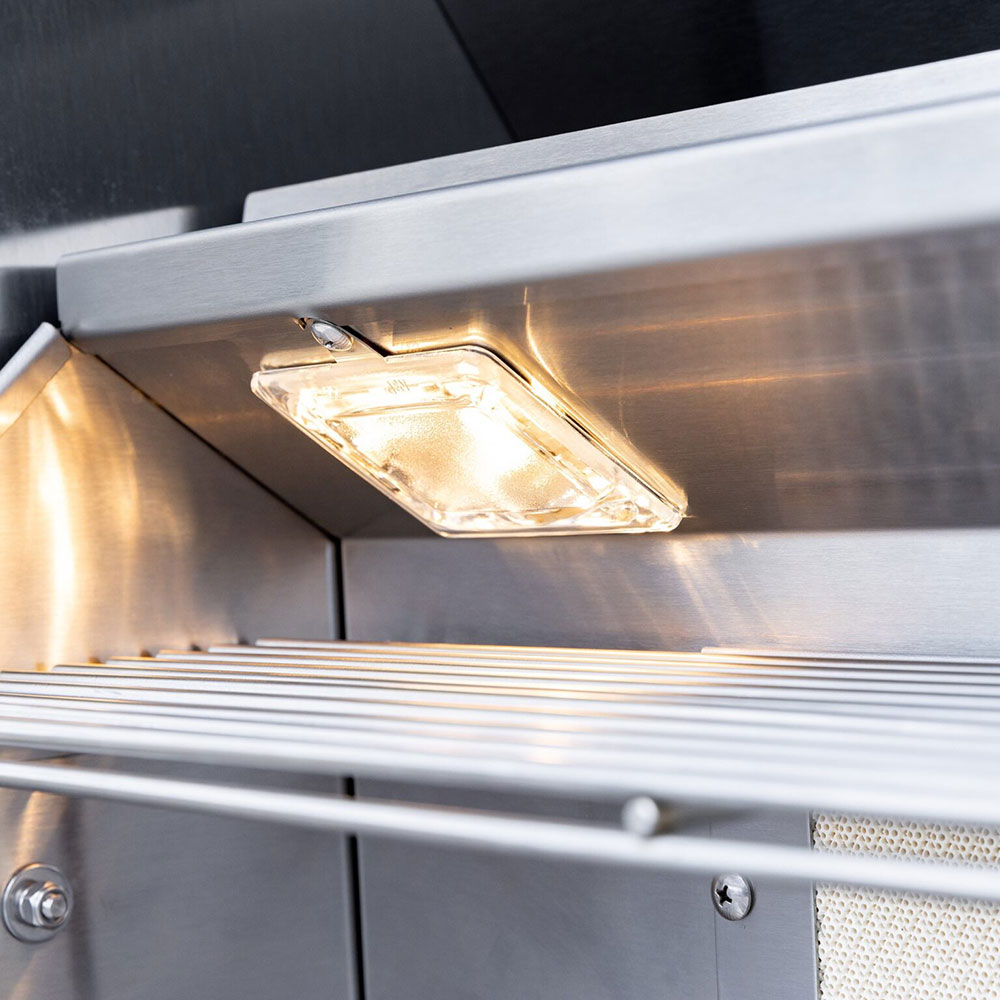 Overhead grill light inside the open lid over the cooking grate area.