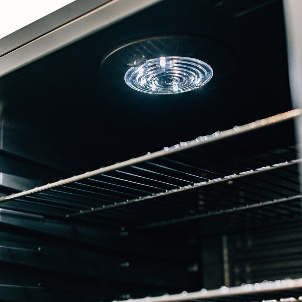 Refrigerator interior ceiling light over wire shelf rails