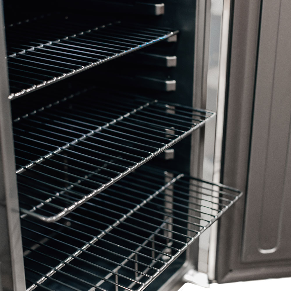 Wire refrigerator shelves inside compact refrigerator, door edge visible.