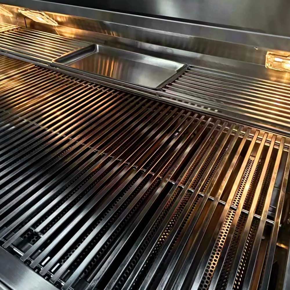 Stainless steel gas grill cooking grates and flame tamers inside the firebox