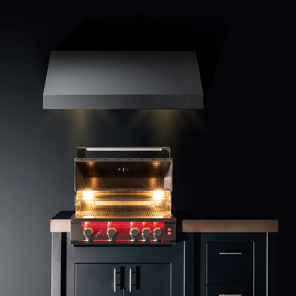 Stainless built-in gas grill with lid raised and illuminated control area