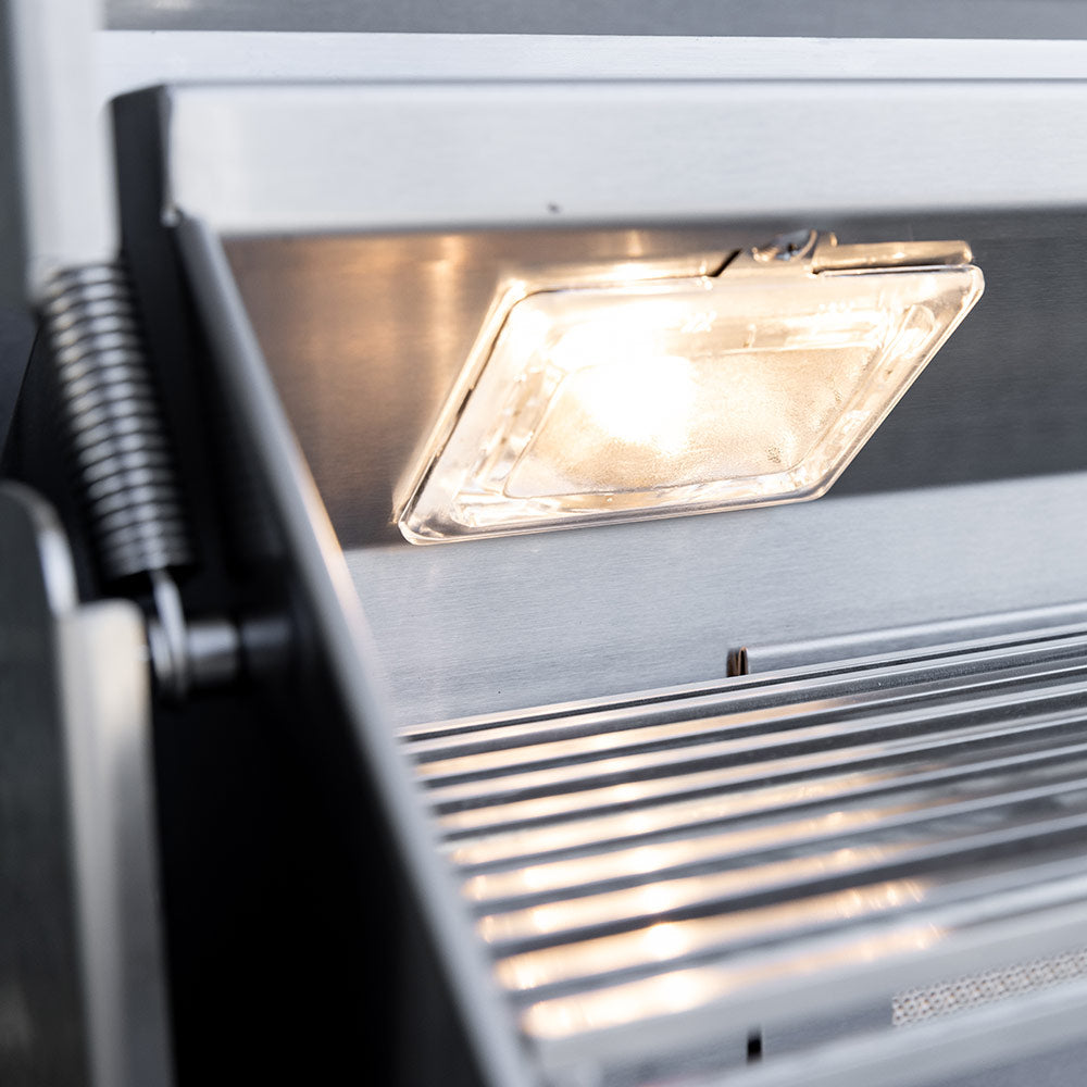 Stainless gas grill cooking area with lit burner tray