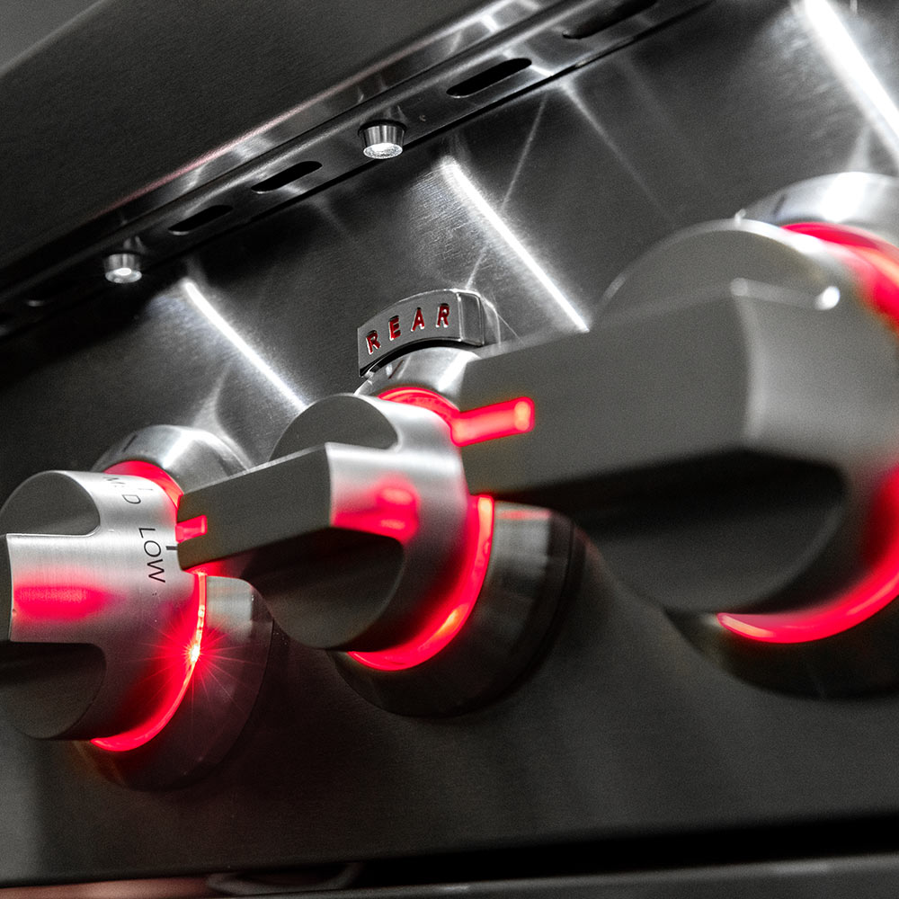 Stainless gas grill control knobs with red-lit indicators and dial