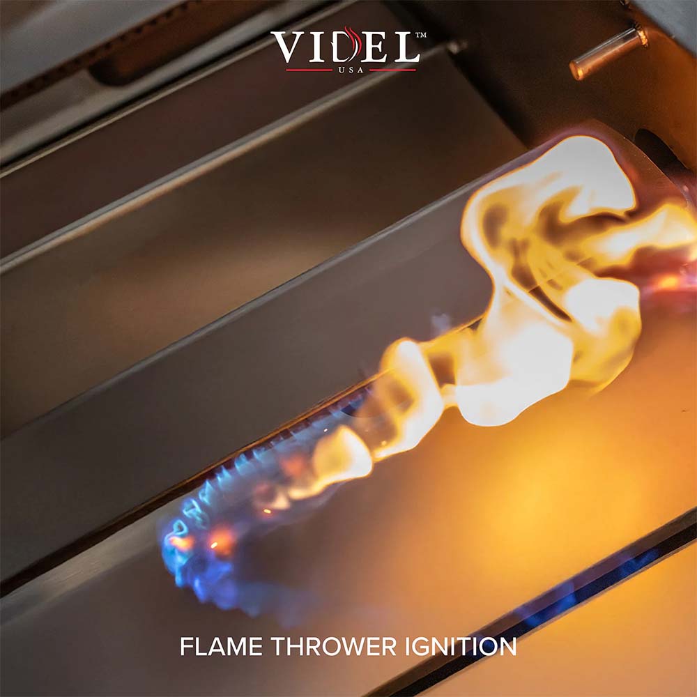 Commercial gas grill burner with blue and orange flames from flame-trower ignition