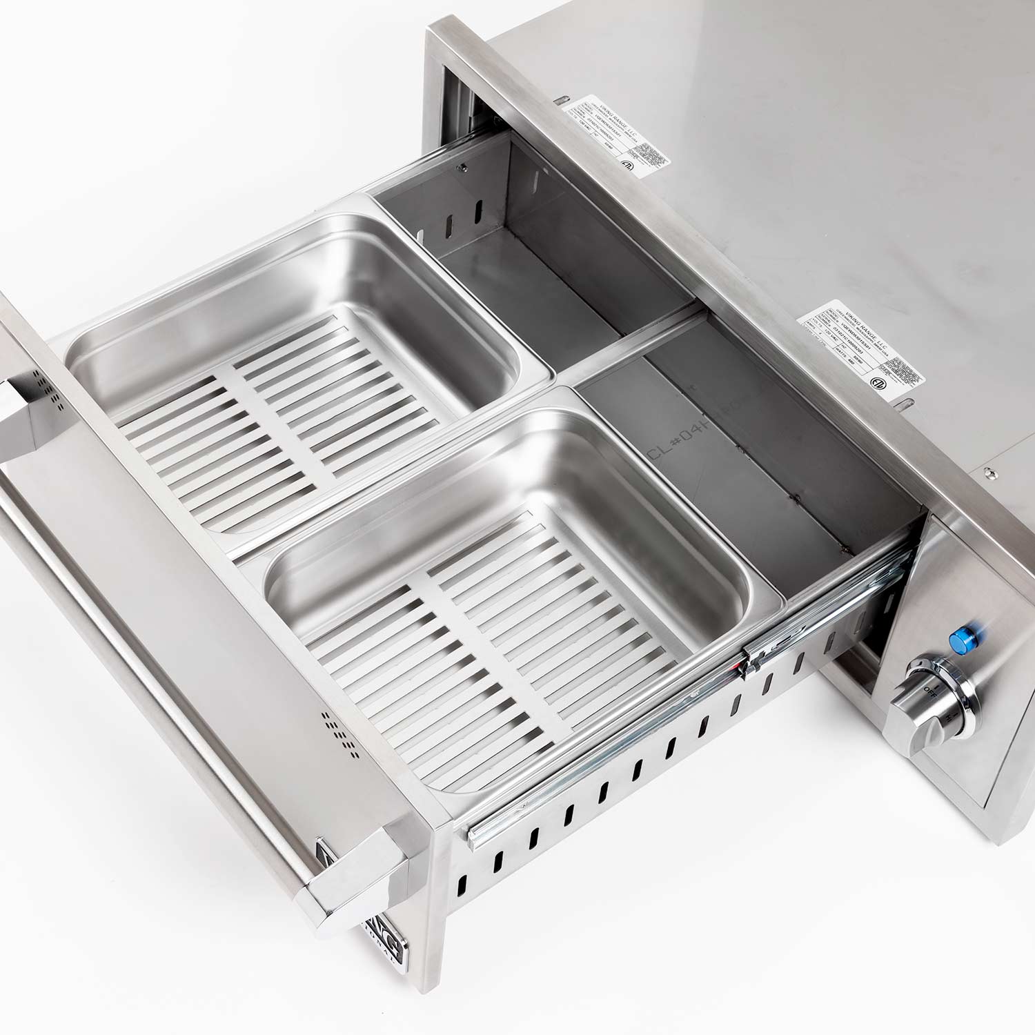 Stainless steel warming drawer interior with two basins and slatted heating inserts.