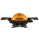 Portable propane grill with side tables, orange lid and black base