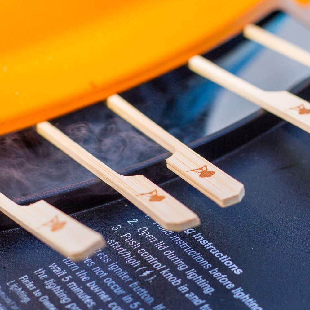 Wooden bamboo skewers laid across a grill grate