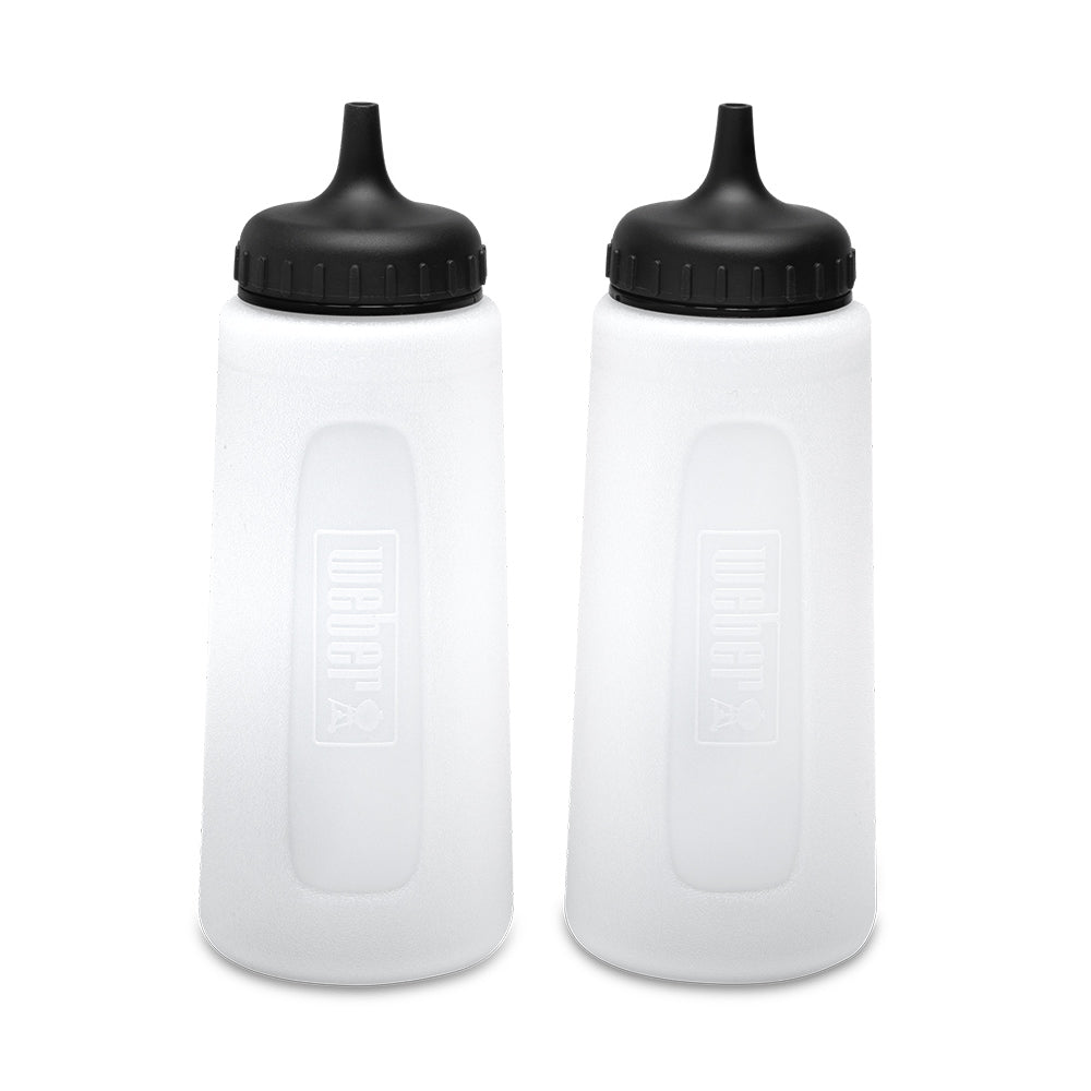 Set of two griddle squeeze bottles, translucent white with black caps and embossed markings