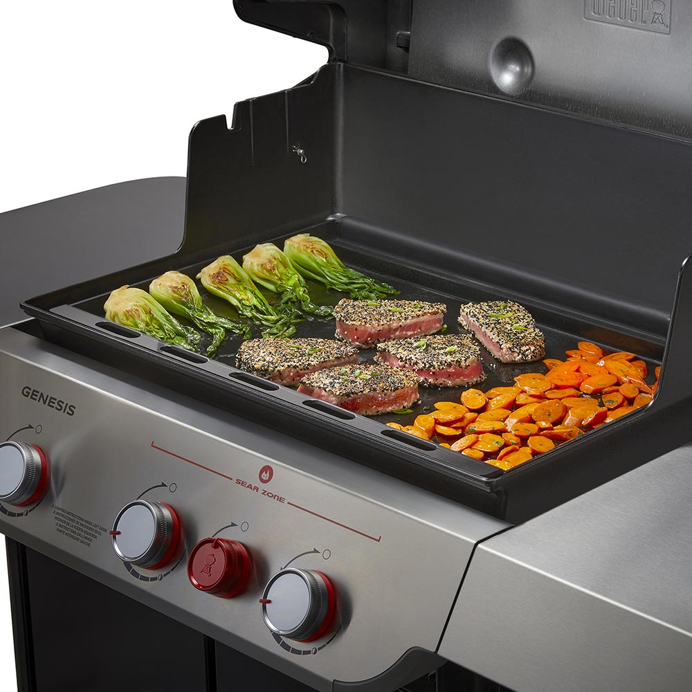 Weber full-size griddle on grill showing vegetables and seasoned steak patties