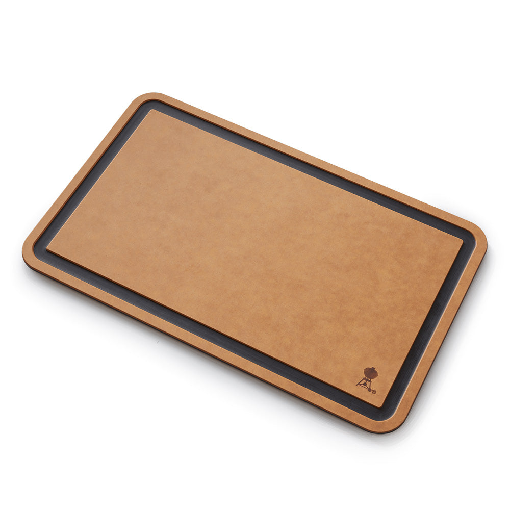 Weber cutting board with tan center panel and dark border, angled view
