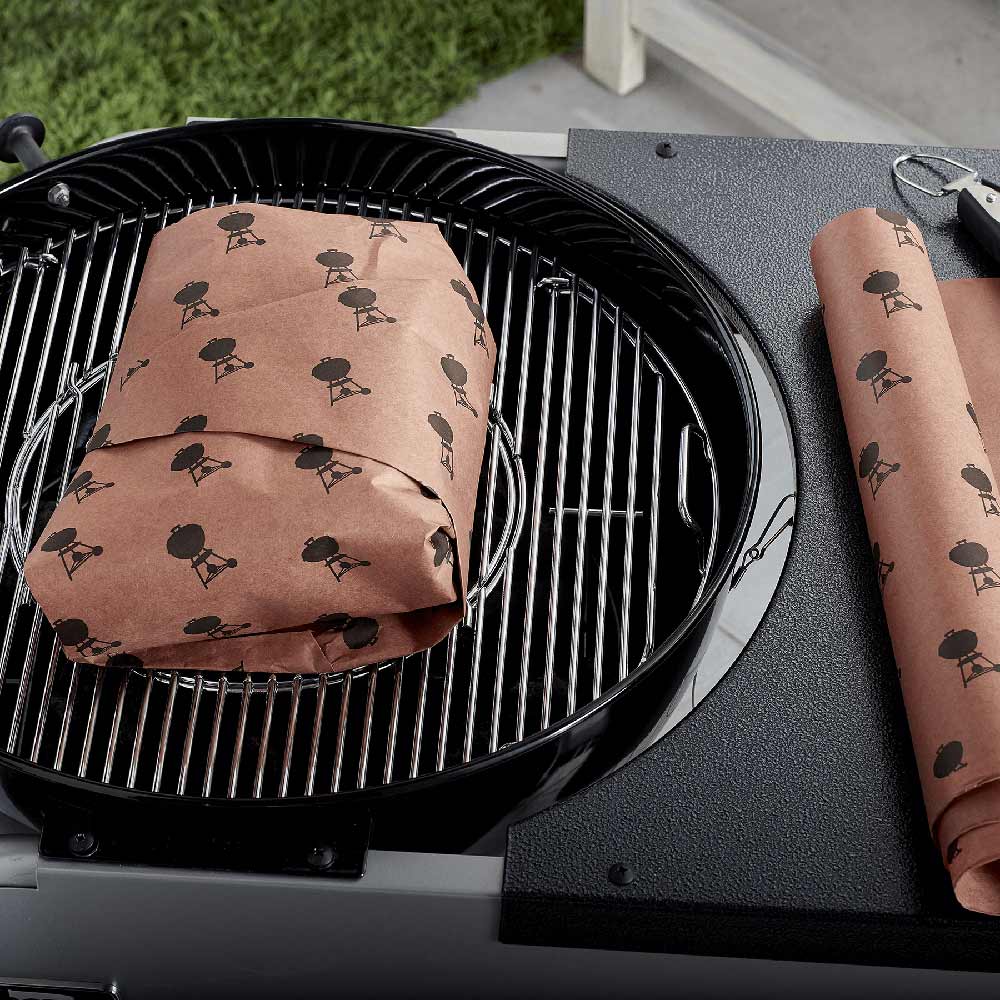Bird-pattern butcher paper roll and sheet placed on a grill grate