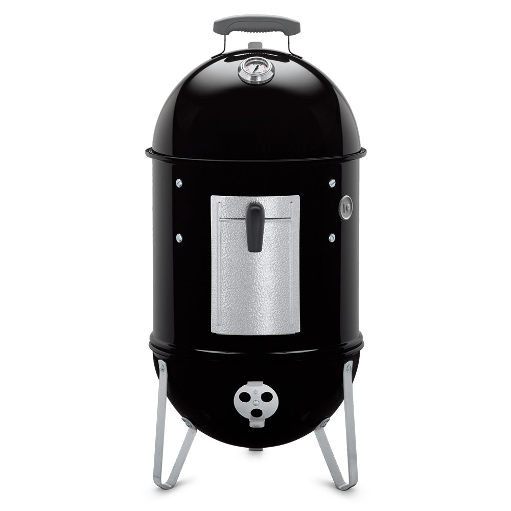 Charcoal smoker with black domed lid, silver ash door, and tripod legs