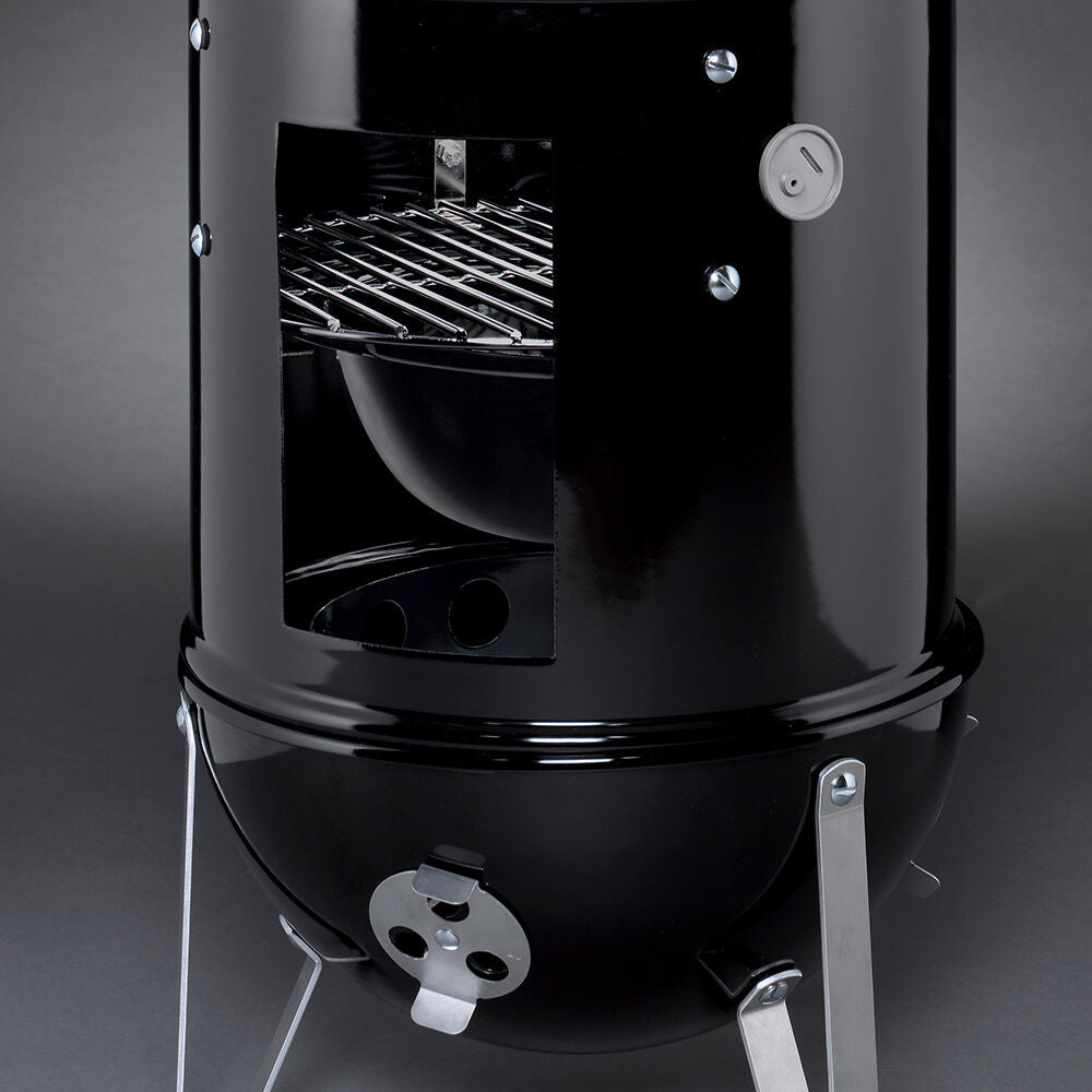 Weber Smokey Mountain charcoal smoker with open side door and interior grates