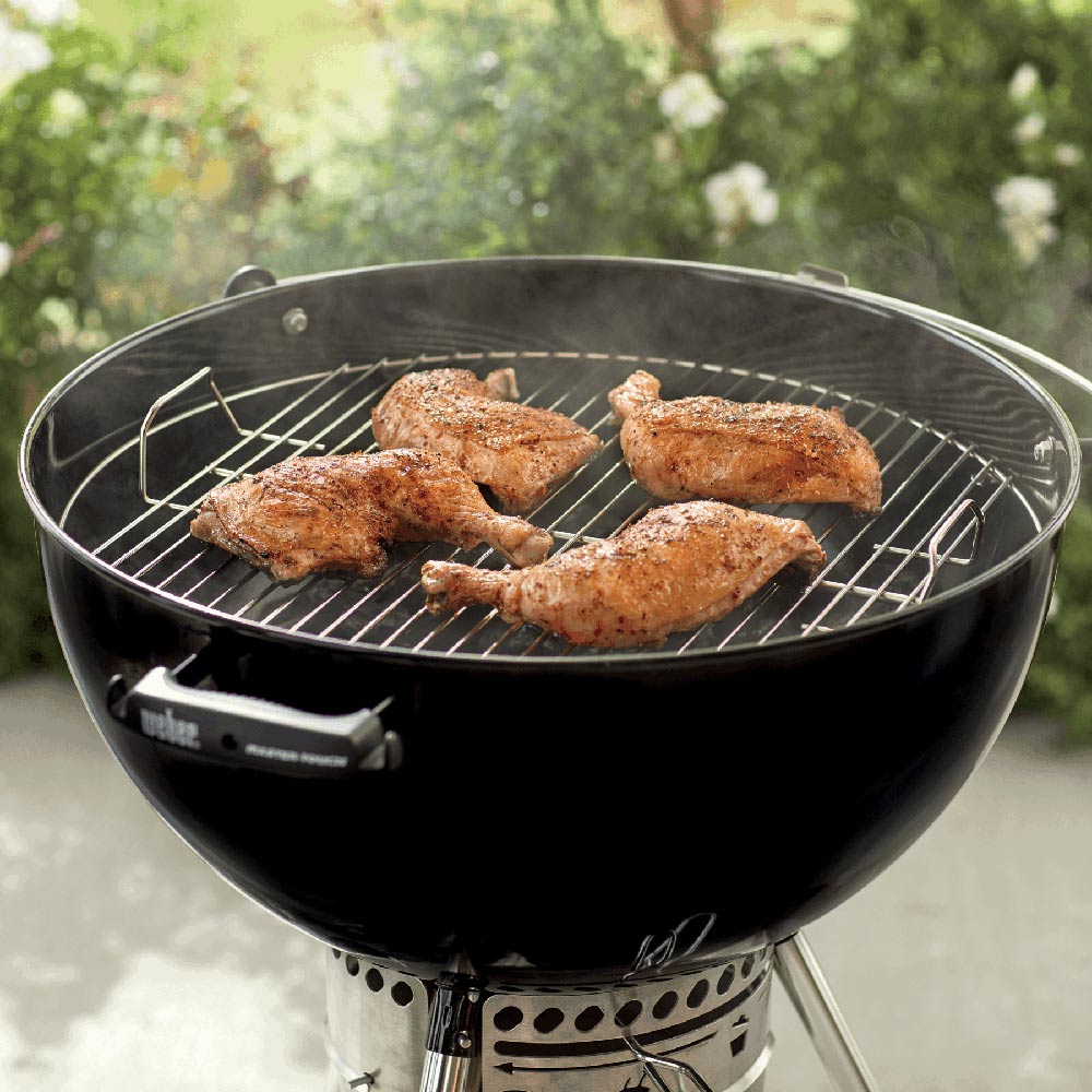 Weber 22-inch round wire cooking grate with grilled food on charcoal grill