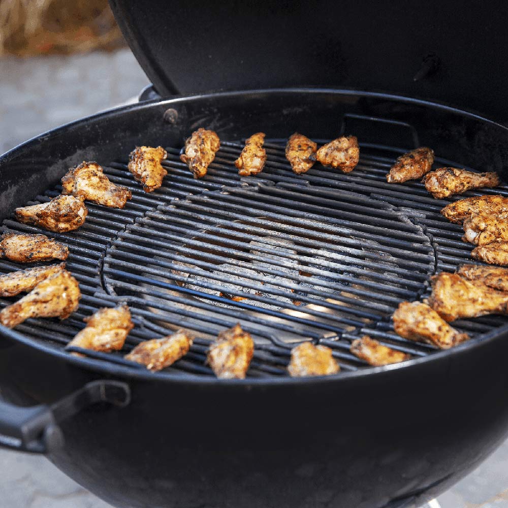 Weber charcoal heat controller, grill grate with seasoned chicken pieces cooking