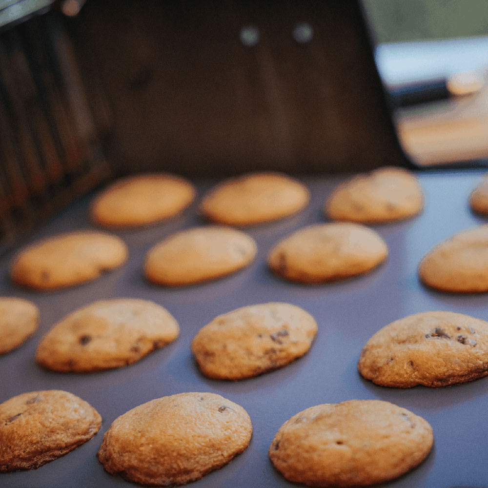Glazed baking stone with round cookies baking on its surface