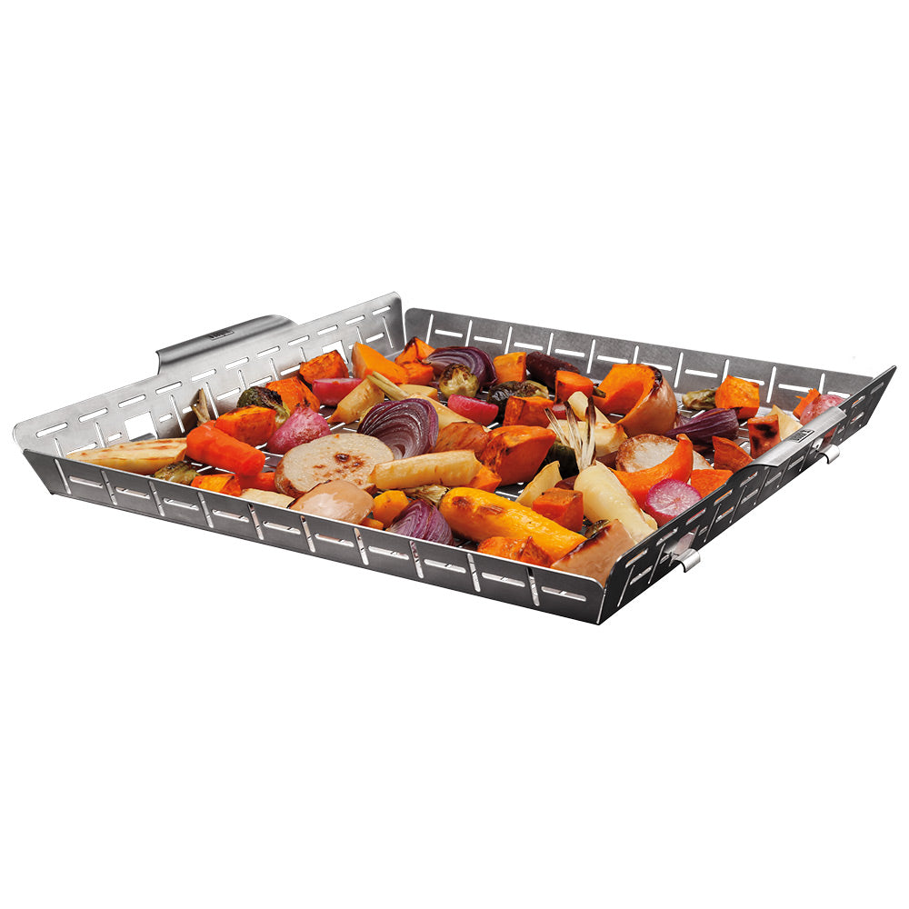 Stainless roasting basket filled with mixed roasted vegetables and herbs