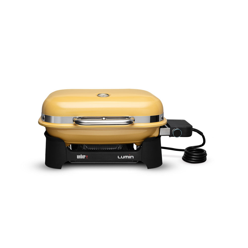 Compact portable electric grill with golden yellow lid, front vents, and power cord