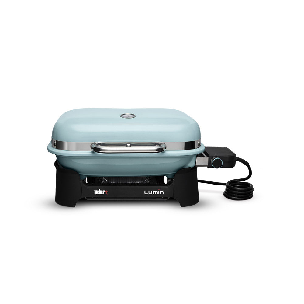 Compact portable electric grill with light blue lid, front vents, and power cord