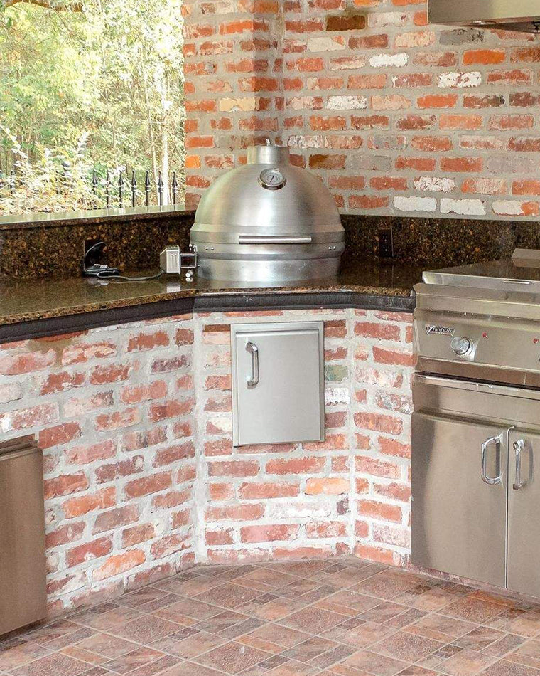 Silver kamado style grill with domed lid and small vent on integrated stand