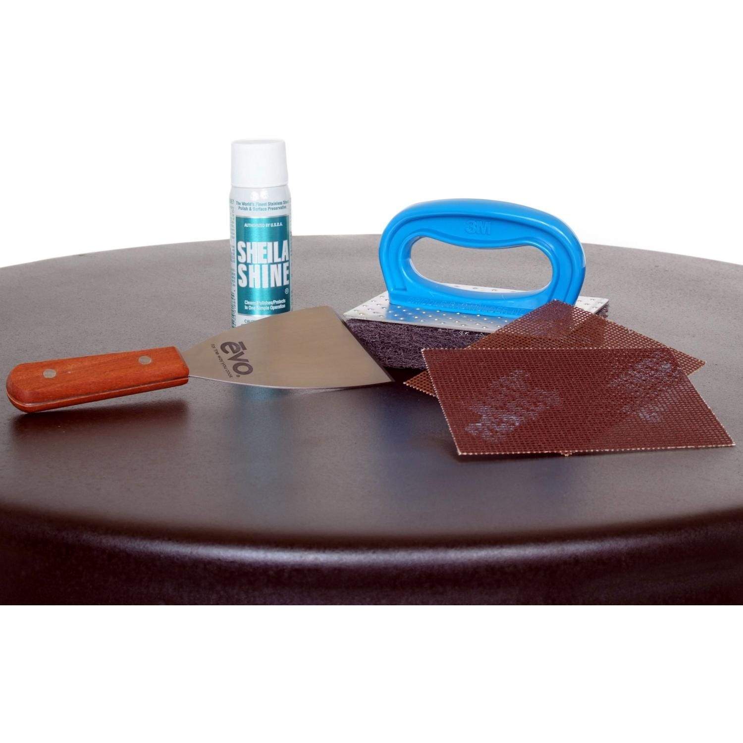 Gas grill cleaning kit with blue scrubber handle, red cloths, orange tool and bottle