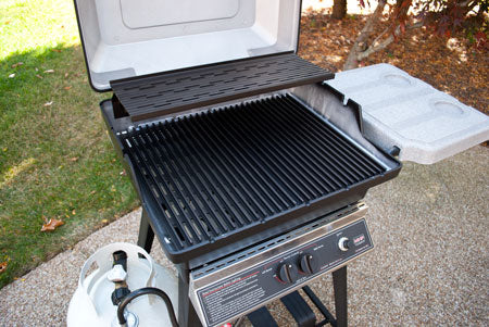22-inch gas grill with side lid open, black grates, and control panel