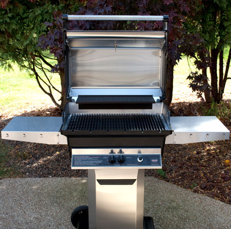 Built-in gas grill with open hood and cooking area visible from front