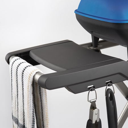 Portable propane grill with black side shelf and control knobs